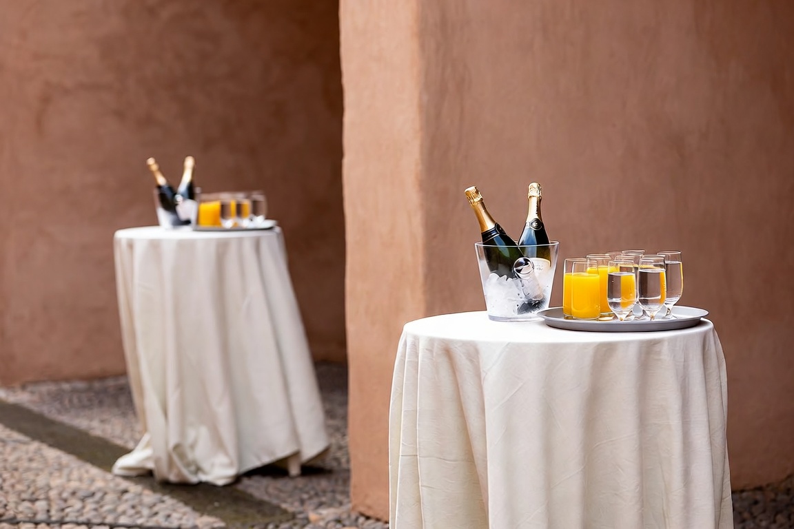 Zwei Stehtische mit Sekt im Eiskübel, Saft und Wasser